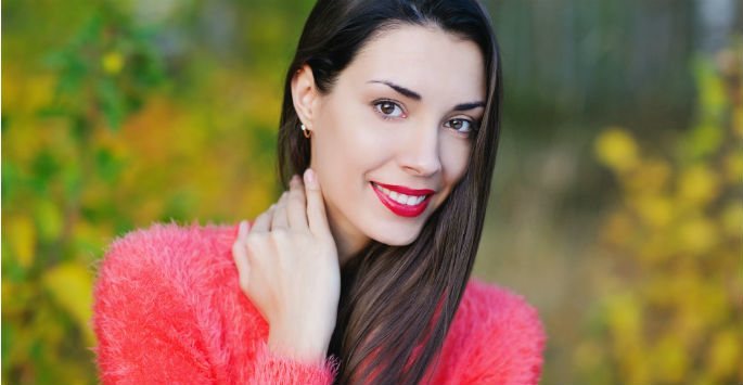 Beautiful woman with long hair and red lips wearing pink blouse