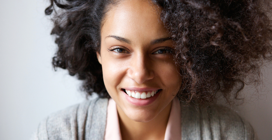 Beautiful young black lady with curly hair smiling