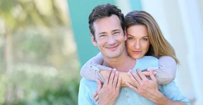 Couple's portrait, the wife is embracing her husband from behind