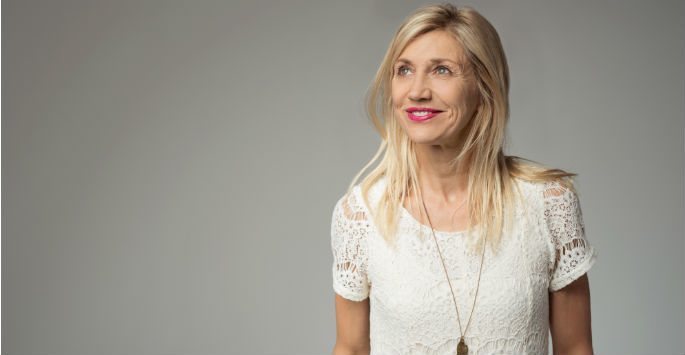 Mature woman with blonde hair and in white lace blouse