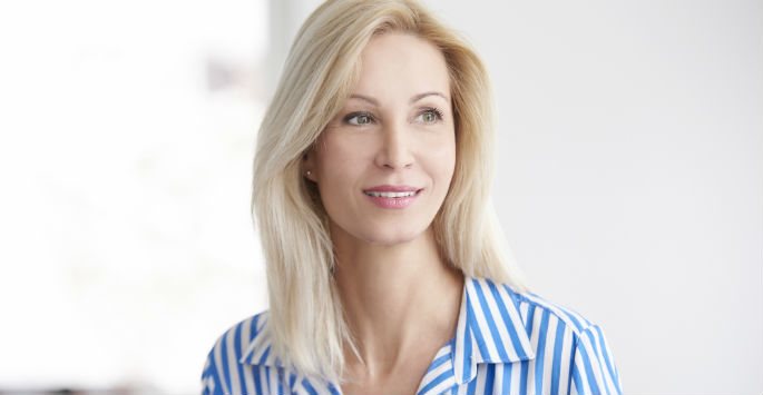 Beautiful woman with blonde hair wearing blue and white striped blouse