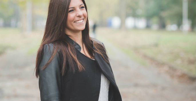 Outdoor portrait of a happy woman wearing a black jacket