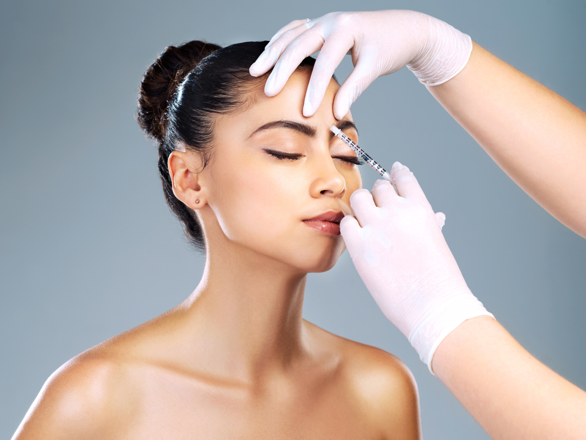 Injectable skincare attractive young woman receiving a botox injection in her face