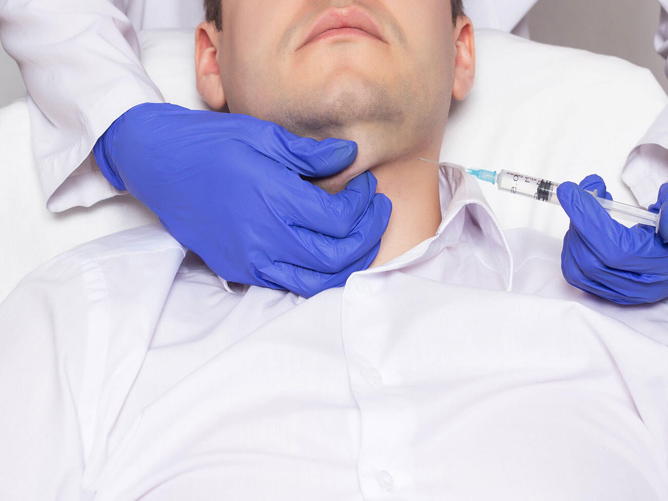 Doctor cosmetologist conducts procedure for a man with a double chin injection of lipolytic drugs, close-up, medical