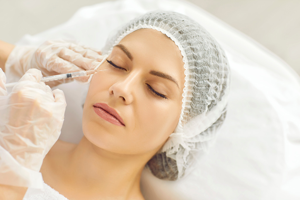 Young lady receives filler injection in lower eye lid